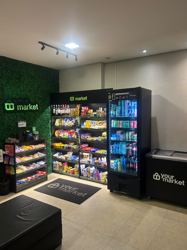 Loja Your Market com jardim vertical, logo iluminado, gôndolas e geladeira de refrigerados